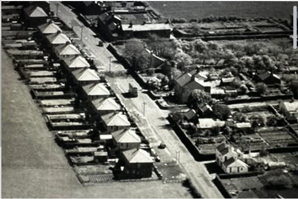 An aerial black-and-white photograph of Moorhouse Road showing rows of back gardens running behind the terraced houses